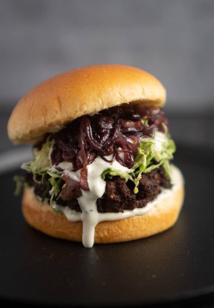 Venison Burger with Red Wine Caramelized Onions, Blue Cheese Sauce and Shaved Brussel Sprouts